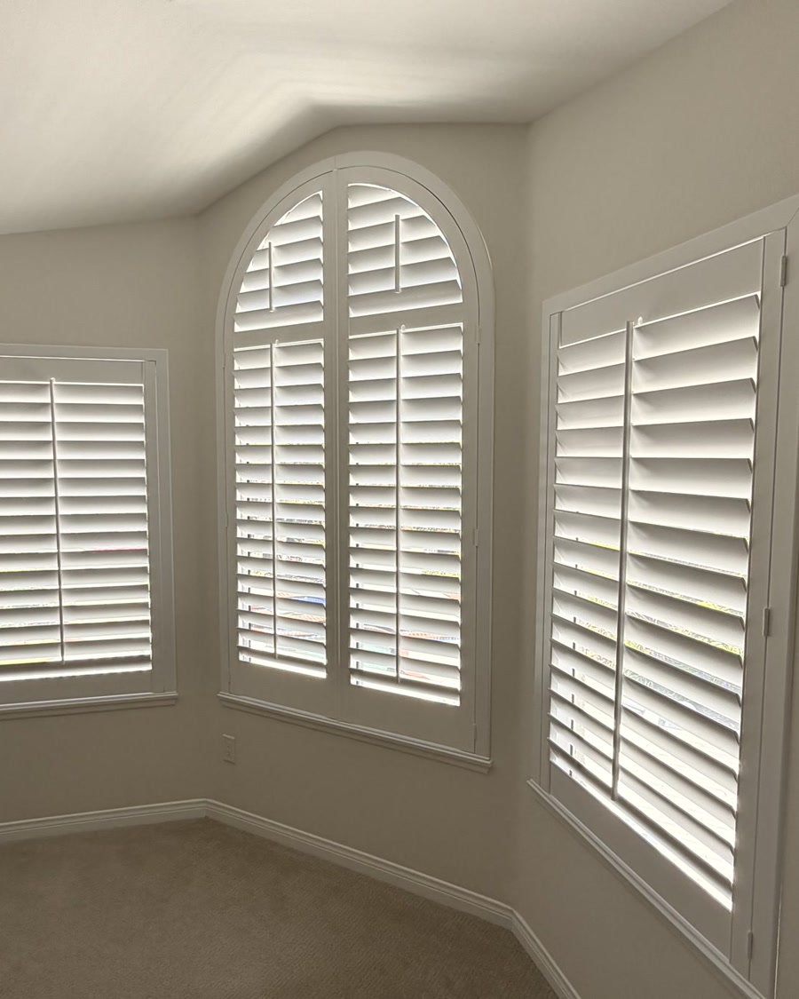 White plantation shutters with an arched center bedroom window in Ventura County