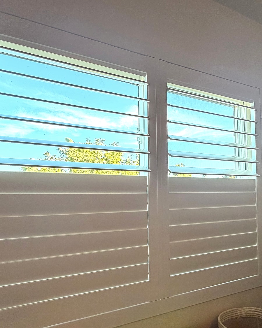 Wide angle view of white plantation shutters in a Ventura County bedroom