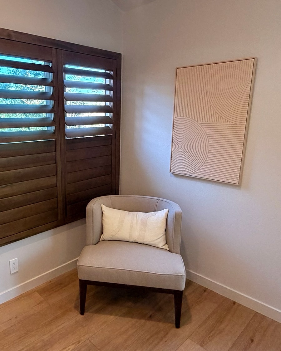 Dark wood plantation shutters in a Ventura County reading room installed by 805 Shutters Shades and Blinds.
