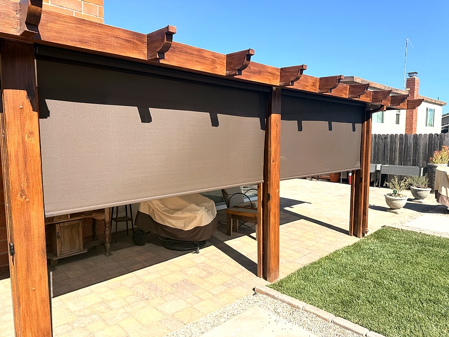 Exterior shades lowering across a custom wood pergola patio in Ventura County