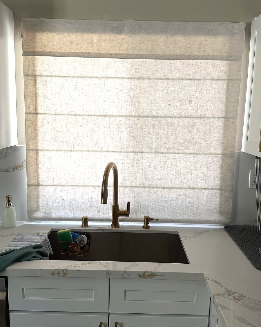 Textured Roman shade lowered over a Ventura County kitchen sink window