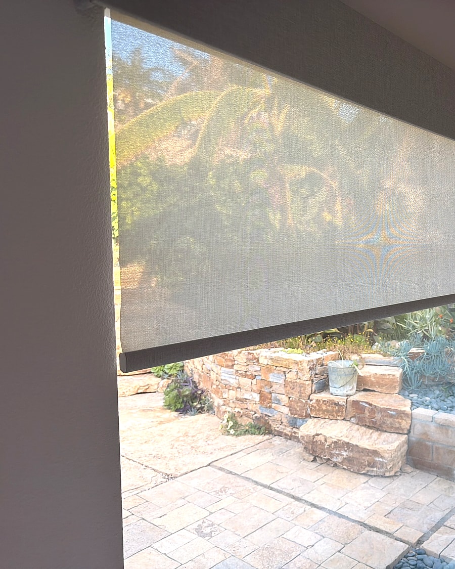 Solar roller shade detail over a patio view