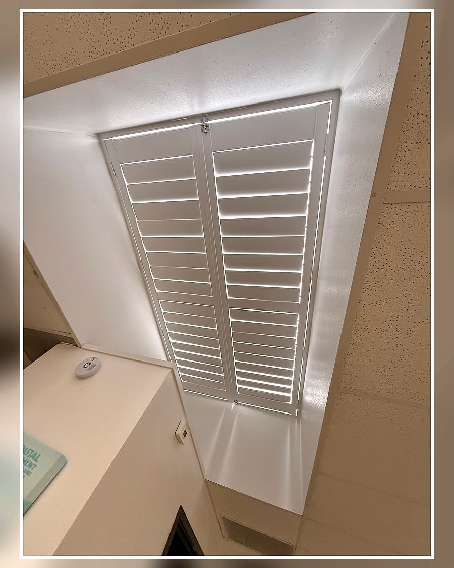 Custom white plantation shutters closed over a Ventura County skylight for light control