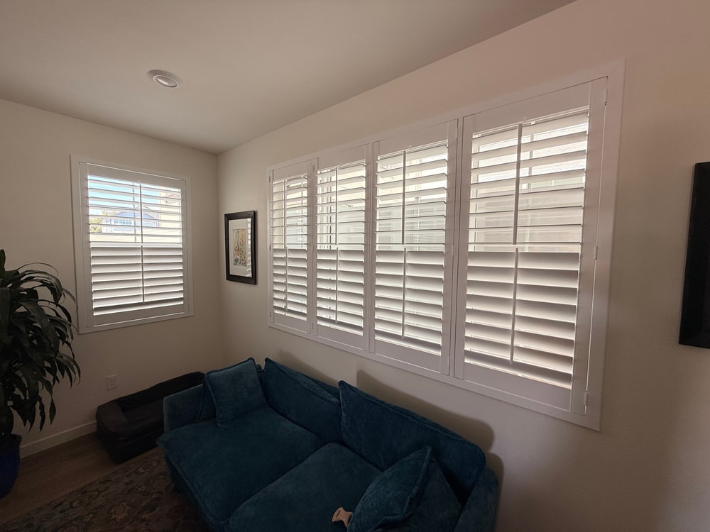 White split tilt plantation shutters installed across a Ventura County living room