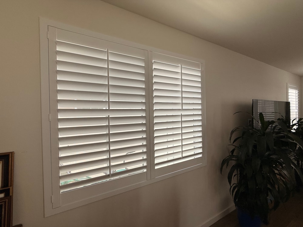 Custom split tilt plantation shutters with the upper louvers open for daylight