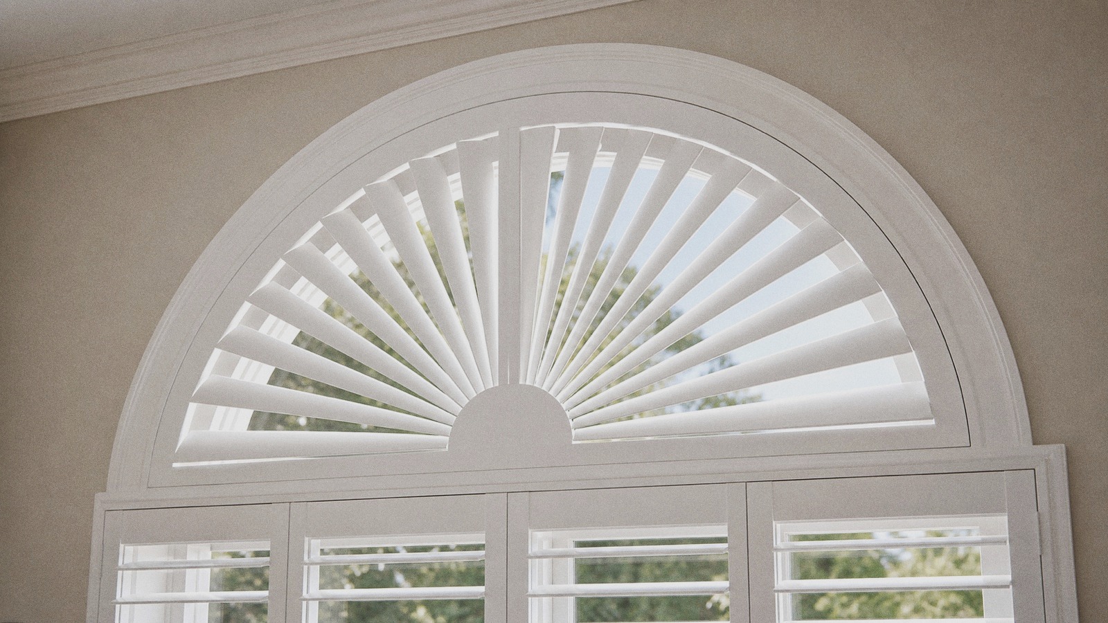 White sunburst plantation shutter with radial fan louvers